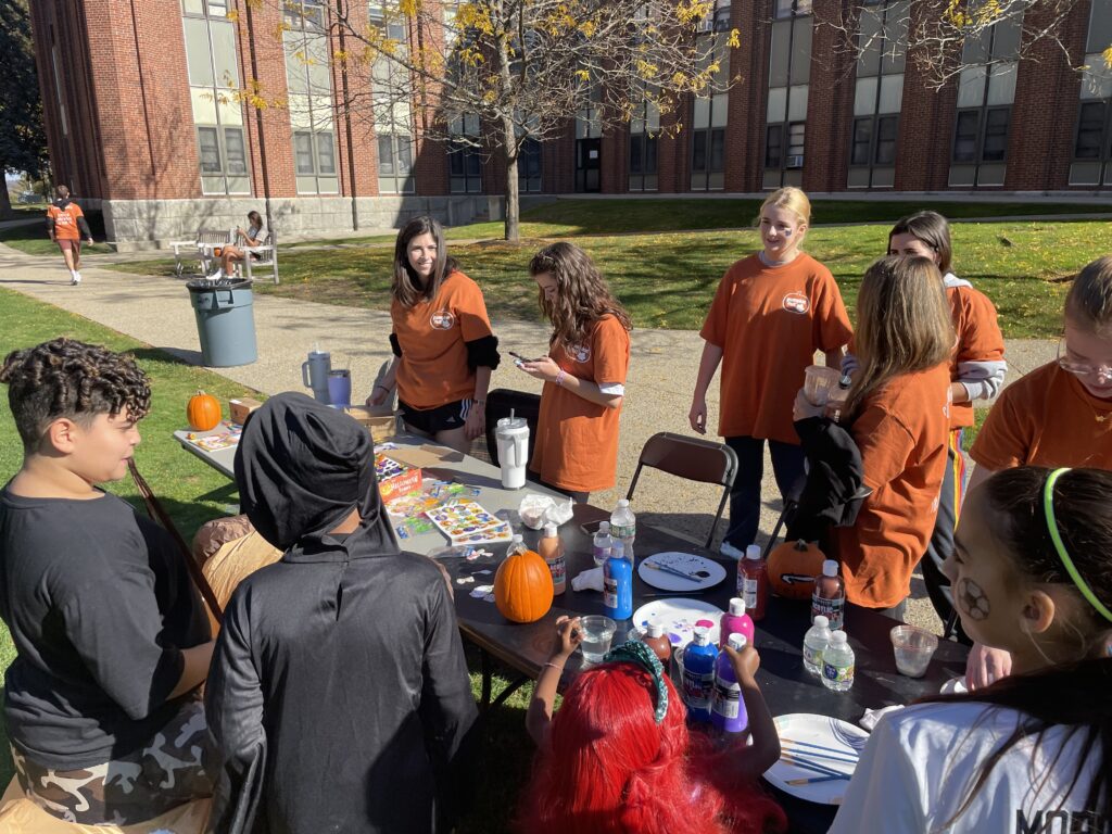 PC students and children from the community painting pumpkins